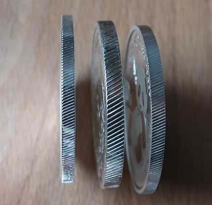 A comparison between two authentic Chinese Silver Pandas and one counterfeit silver Pandas by comparing their thickness.