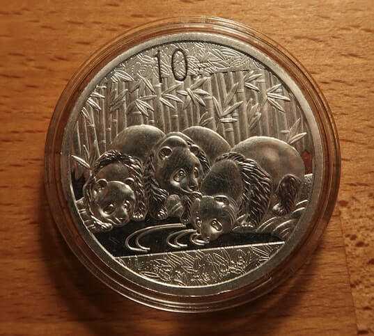 An image of a counterfeit 2013 Chinese Silver Panda in a capsule with no nibs.