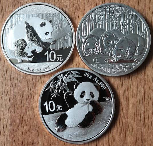 An Image of the several authentic Chinese Silver Pandas along with a counterfeit Chinese Silver Panda 