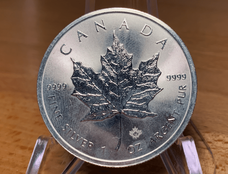 The reverse of a 2016 silver maple leaf coin covered in milk spots.